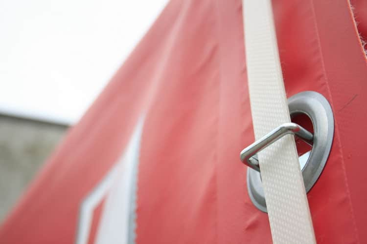 Industrial strength eyelets on red trailer cover